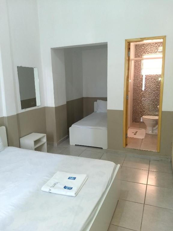 Habitación con cama y baño con espejo. en Hotel Aruba, en Curitiba