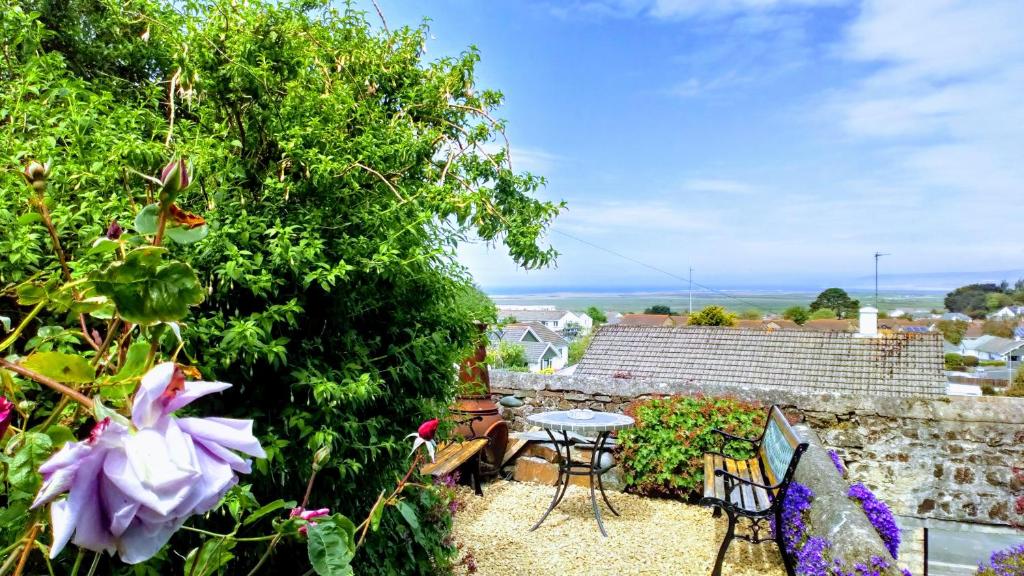 a garden with a table and chairs and flowers at sea view cottage in Bideford