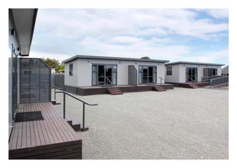 a couple of white buildings in a parking lot at Pine Lake View Lodge in Kaiapoi