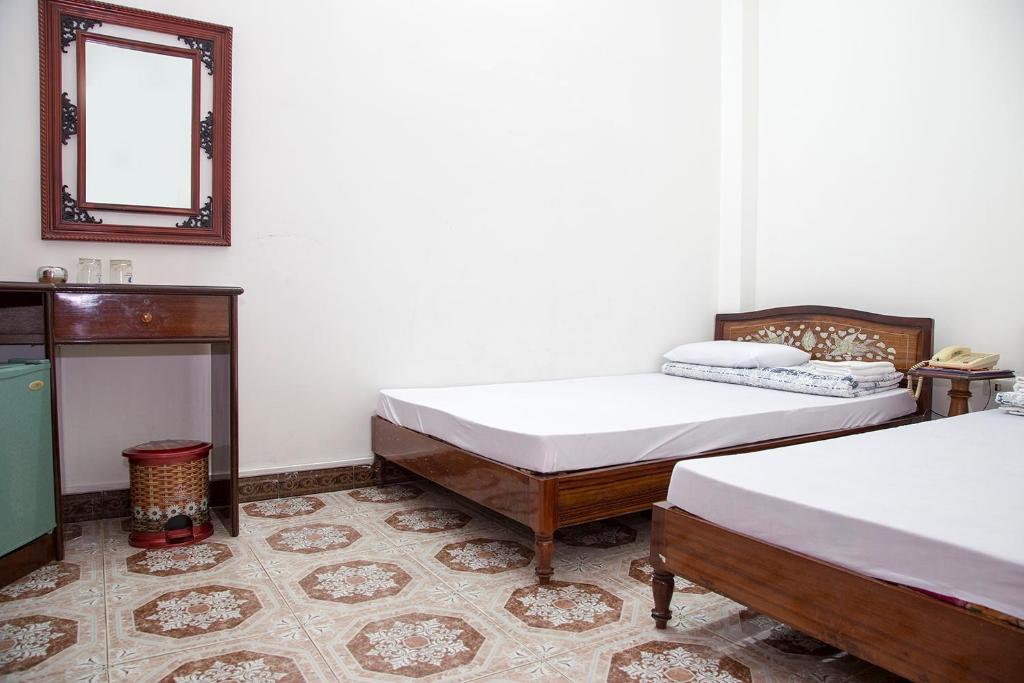 Cà Mau的住宿－宋紅酒店，一间设有两张床的客房和墙上的镜子