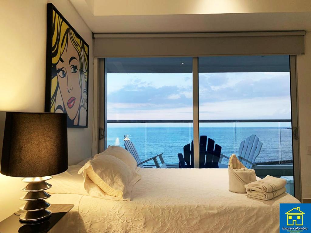 a bedroom with a bed and a view of the ocean at Apartamentos Cartagena Oceano - Eliptic in Cartagena de Indias