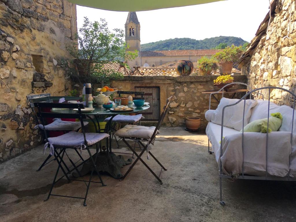 una mesa y sillas en un patio con chimenea en Les chambres d'Elise, en Collias