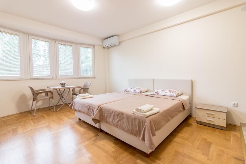 a white bedroom with a bed and a table at Comfy Apartments-Ohrid in Ohrid