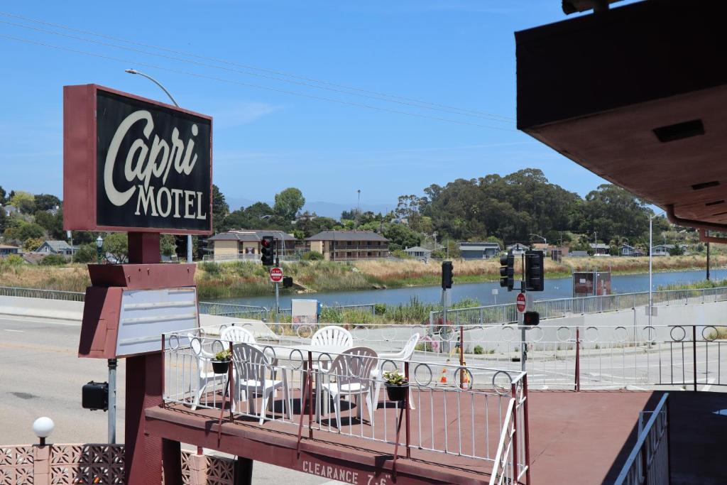 a restaurant with white tables and chairs on a balcony at Capri Motel Santa Cruz Beach Boardwalk in Santa Cruz