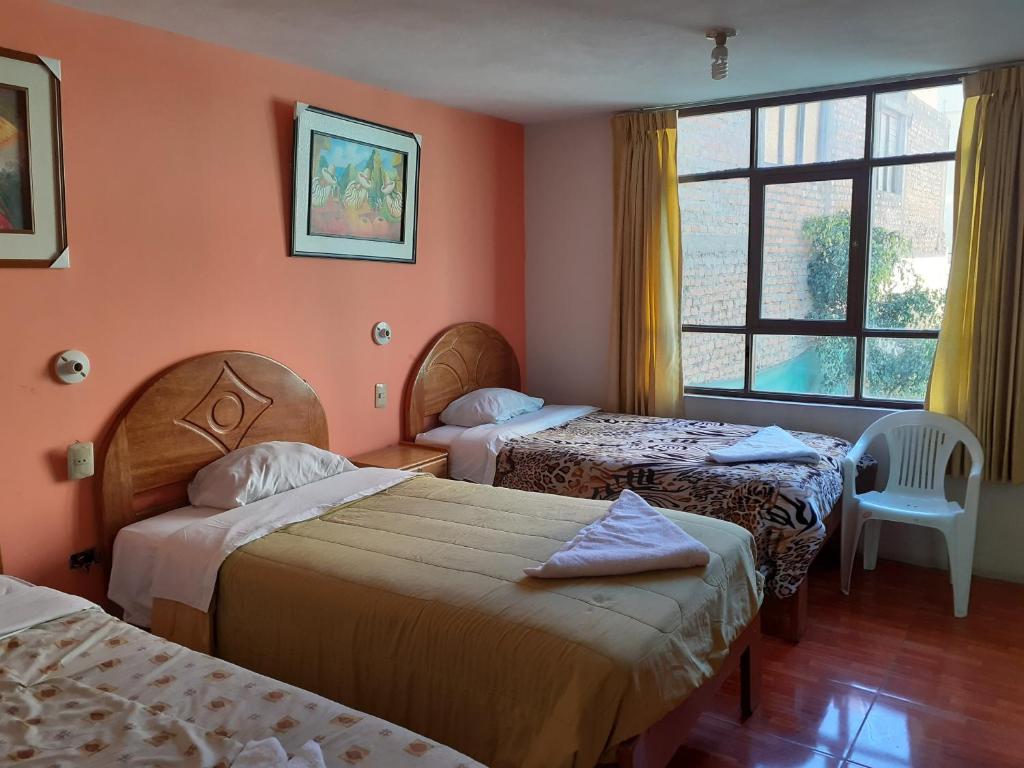 Habitación de hotel con 2 camas y ventana en Waikycha Hostal, en Arequipa