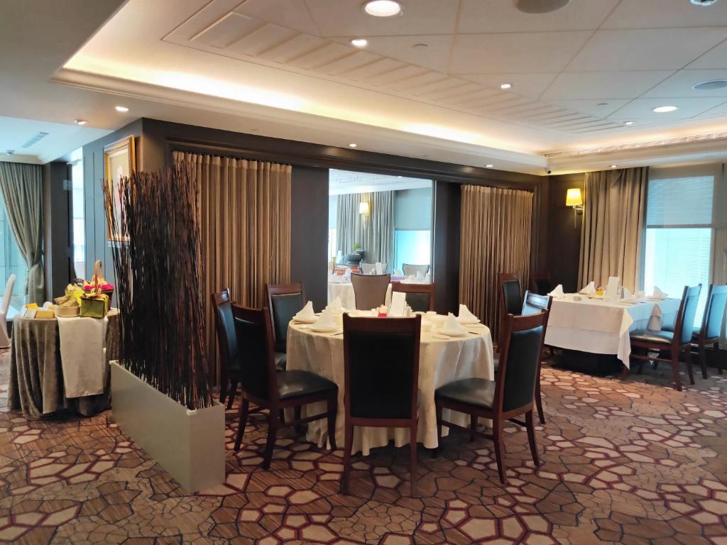 a dining room with white tables and chairs and tablesearcher at Evergreen Laurel Hotel Taipei in Taipei