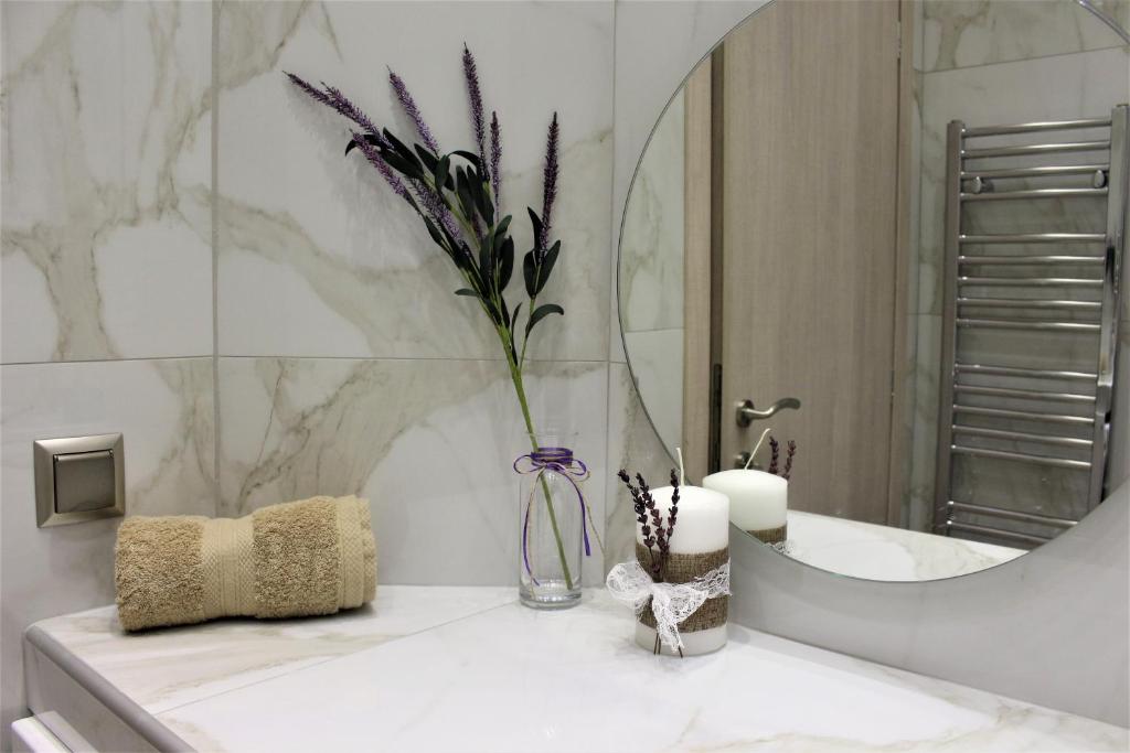 ein Badezimmer mit einer Vase mit lila Blumen darin in der Unterkunft Aristotelous Forum Apartment in Thessaloniki