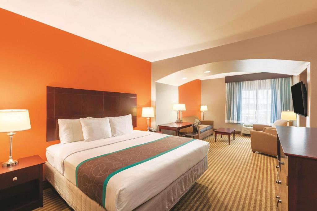 a hotel room with a large bed and a desk at La Quinta by Wyndham Houston IAH Bush Intl Airport E in Humble