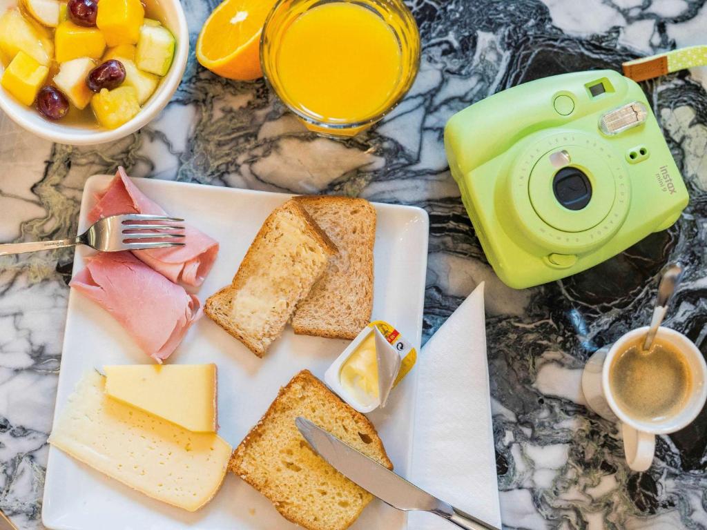 a table with a plate of cheese and bread and a cup of coffee at ibis Styles Paris Nation Cours de Vincennes in Paris