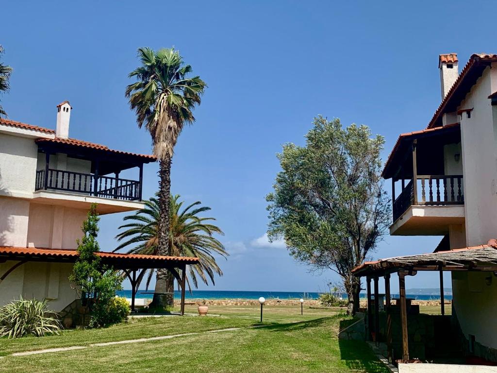 a resort with palm trees and the ocean in the background at Villa Fourka 2 on the beach in Fourka