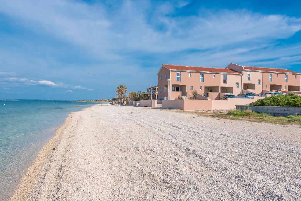 una playa con una casa y el océano en LUXURY APARTMENTS - LA VIR 3 & 4, en Vir