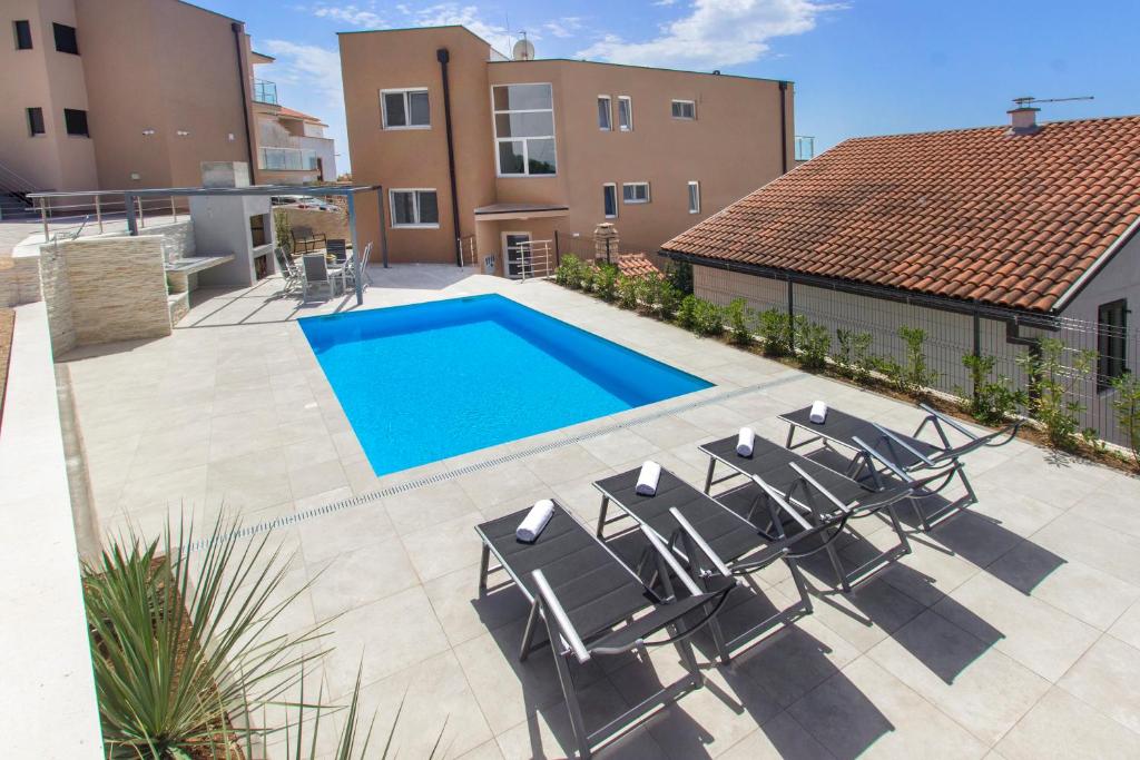 a patio with chairs and a swimming pool at Villa Ilenia in Murter