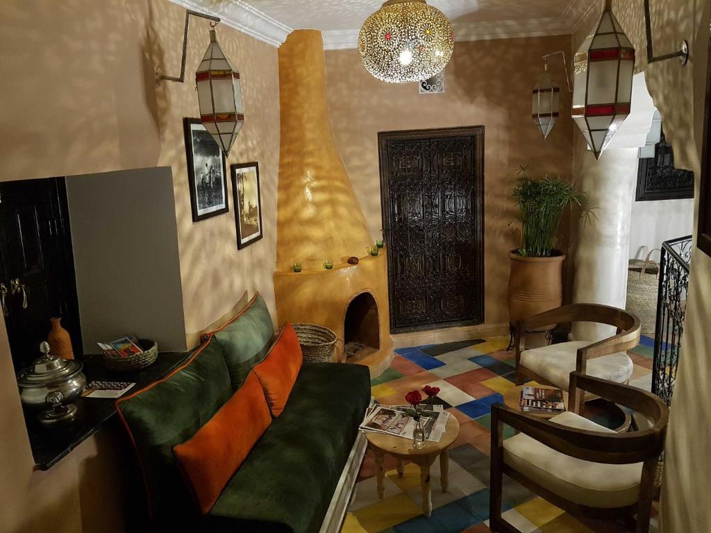 a living room with a couch and a table at Riad Bilkis the magic of Marrakech in Marrakesh