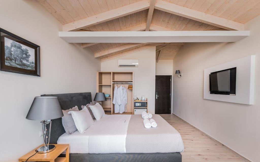 una camera con un grande letto e un divano di Crystal Beach Hotel a Kalamákion