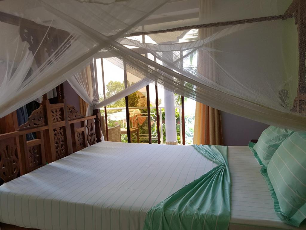 a bedroom with a white bed with a canopy at Daeli Apartment in Kendwa