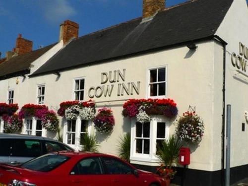 a red car parked in front of a dum cow inn at Dun Cow Inn in Sedgefield