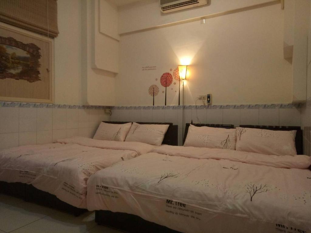 duas camas sentadas uma ao lado da outra num quarto em Xincun Seed Homestay em Anping