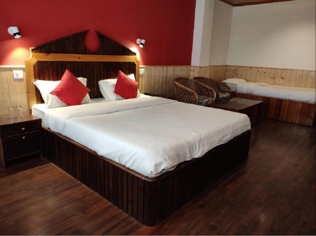 a bedroom with a large bed with red walls at Hotel Madhuban Shimla in Shimla