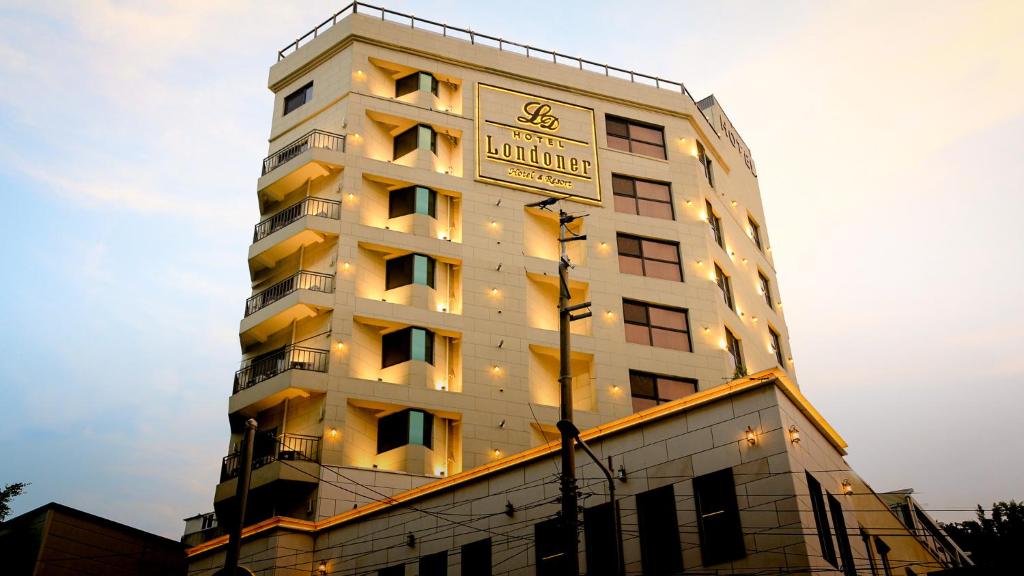 um edifício branco alto com um relógio em Londoner Hotel Gwangan em Busan