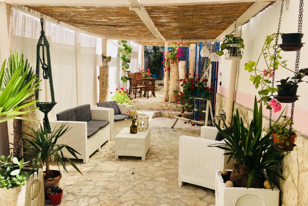 d'une terrasse avec des meubles blancs et des plantes en pot. dans l'établissement Il Giardino dei Limoni, à Vieste