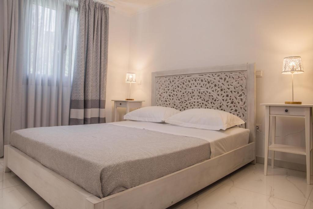 a bedroom with a large bed and two night stands at Small Paradise in Andros