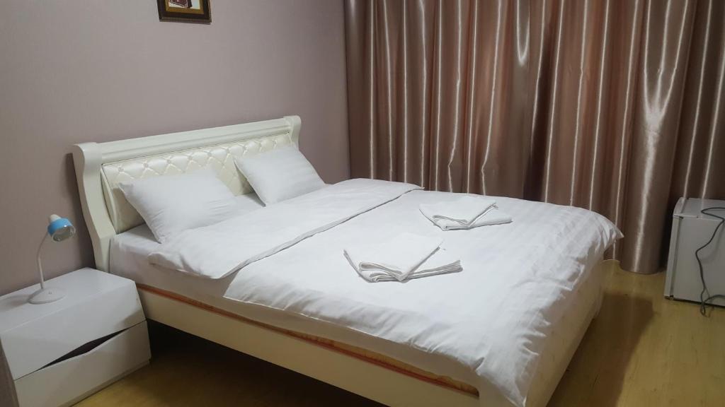 um quarto com uma cama branca com dois pássaros em Wonder Mongolia Guesthouse and Tour Operator LLC em Ulan Bator