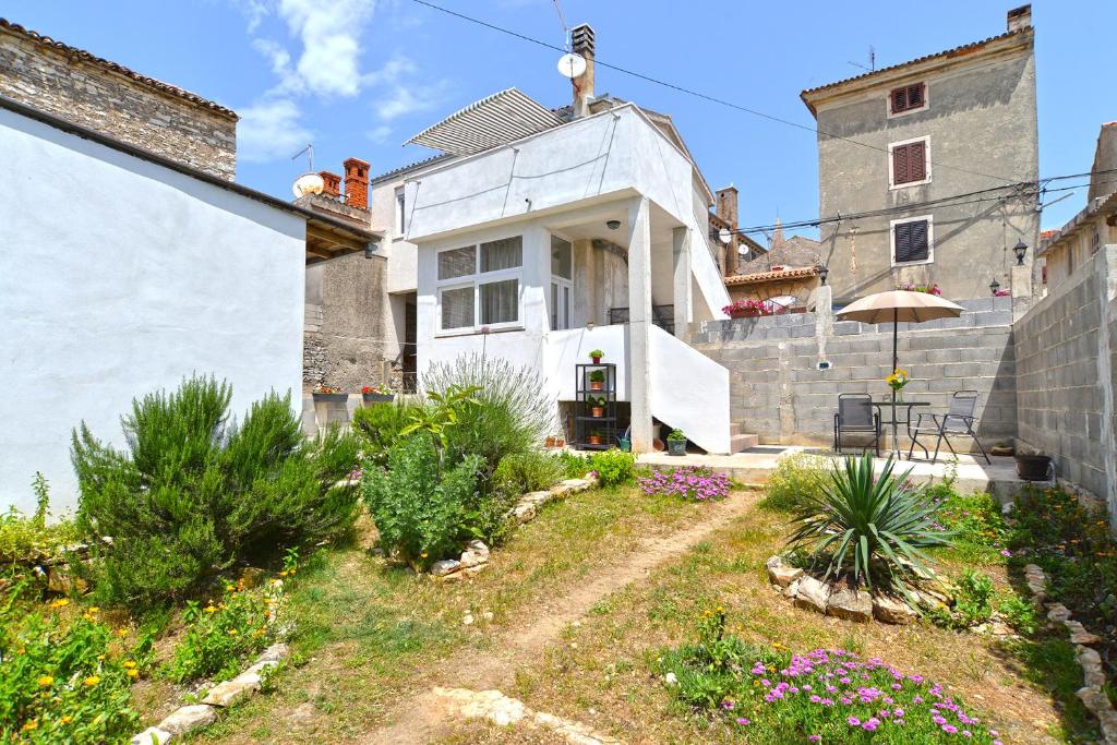 a white house with a garden in front of it at Apartment Senada 1503 in Galižana