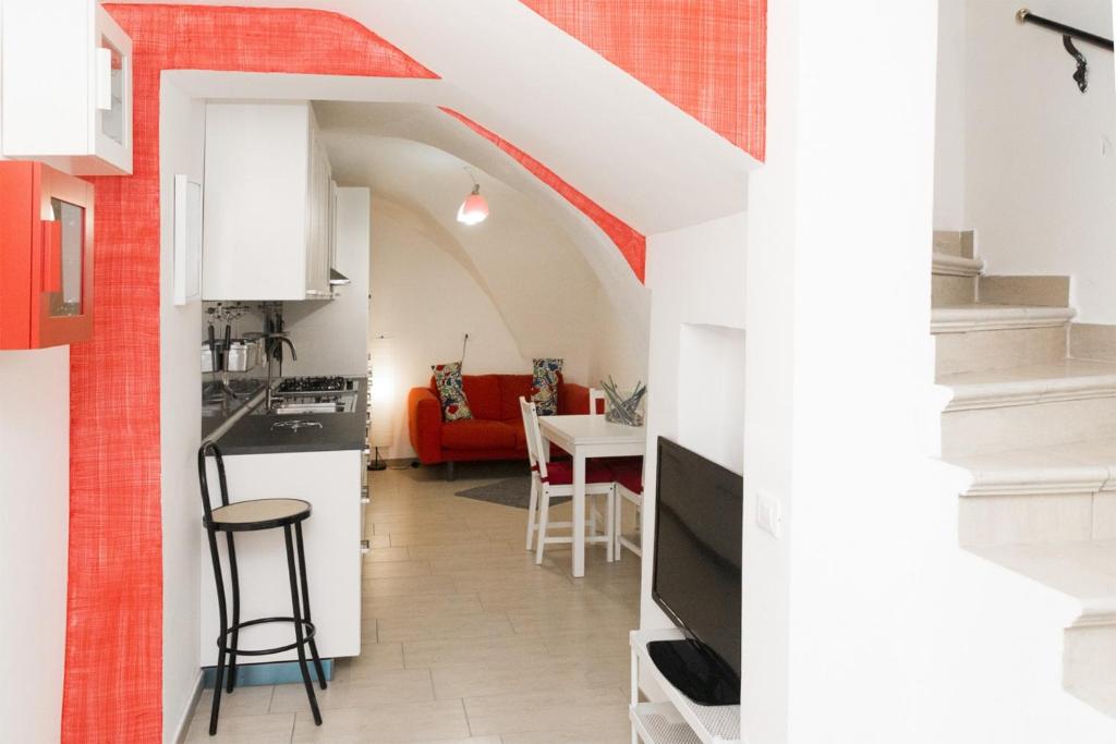 een keuken en een woonkamer met een rode en witte muur bij B&B Teate in Chieti