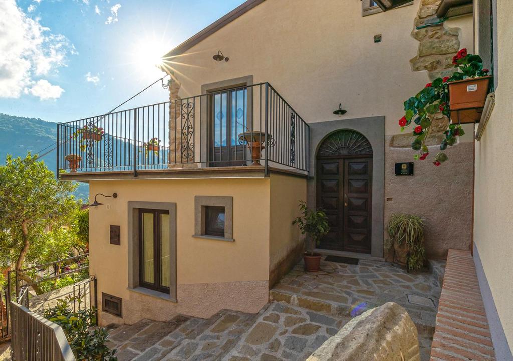 ein Haus mit einem Balkon und einer Tür in der Unterkunft B&B Loreto in SantʼAngelo di Brolo