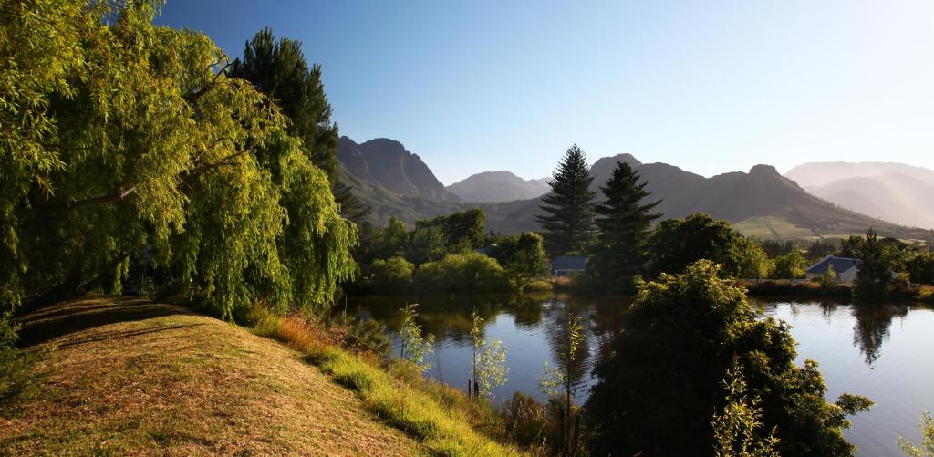 a view of a lake with mountains in the background at Bo La Motte Farm Cottages in Franschhoek