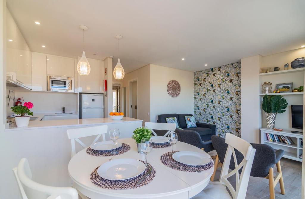 a kitchen and dining room with a white table and chairs at The Old Village, Prestige and Solar by Village 4U in Vilamoura