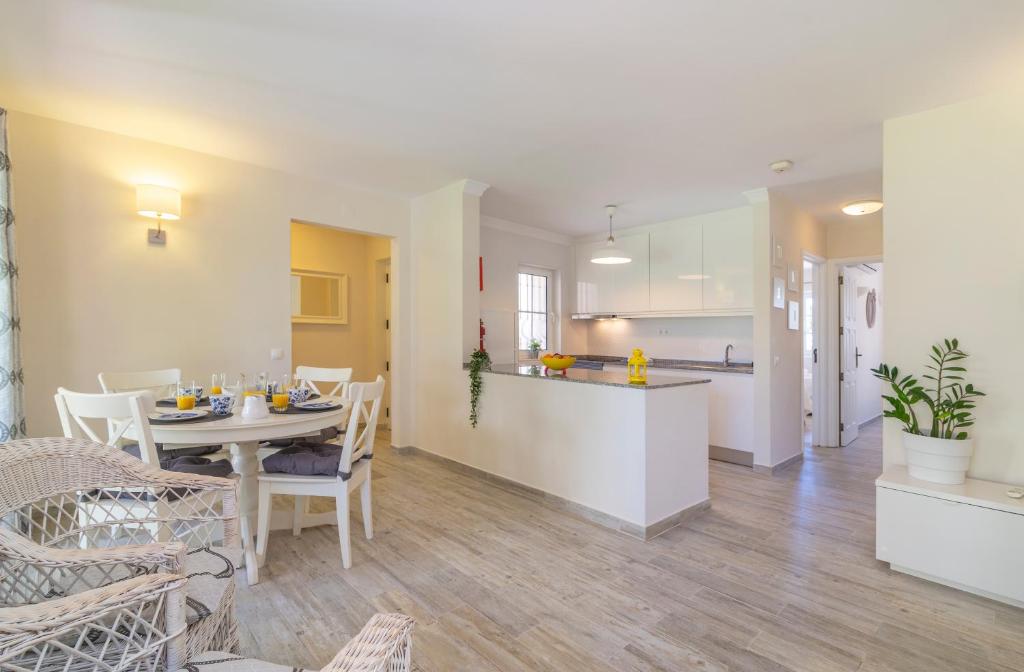 a living room and kitchen with a table and chairs at The Old Village, Prestige and Solar by Village 4U in Vilamoura