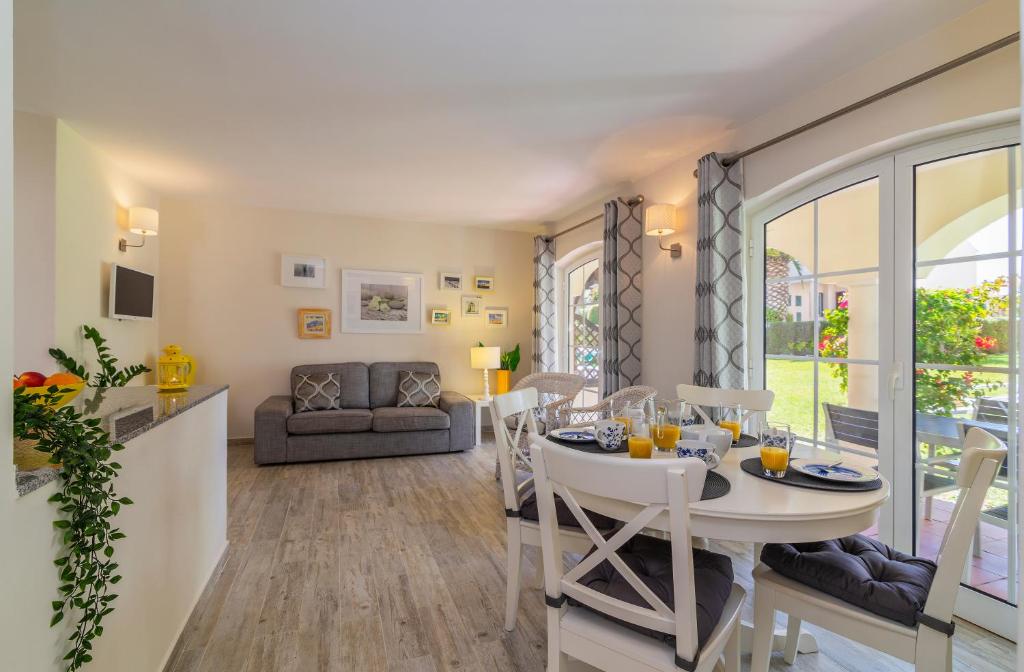 a kitchen and living room with a table and chairs at The Old Village, Prestige and Solar by Village 4U in Vilamoura