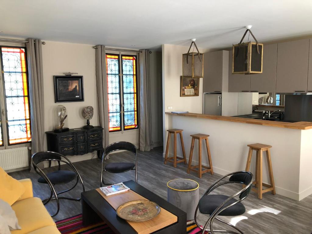 a living room with a counter and a kitchen at Le 39 Bis in Rémalard