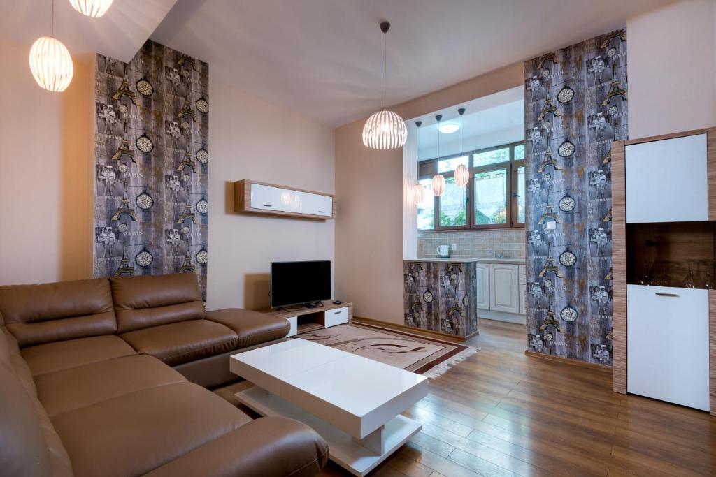 a living room with a couch and a tv at Family Apartment - COMFORT IN THE CENTER in Burgas City
