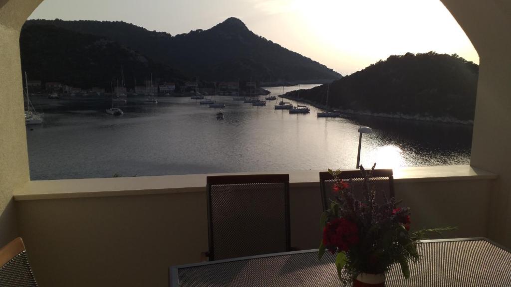 a balcony with a view of a river with boats at Apartment Zaklopatica in Lastovo