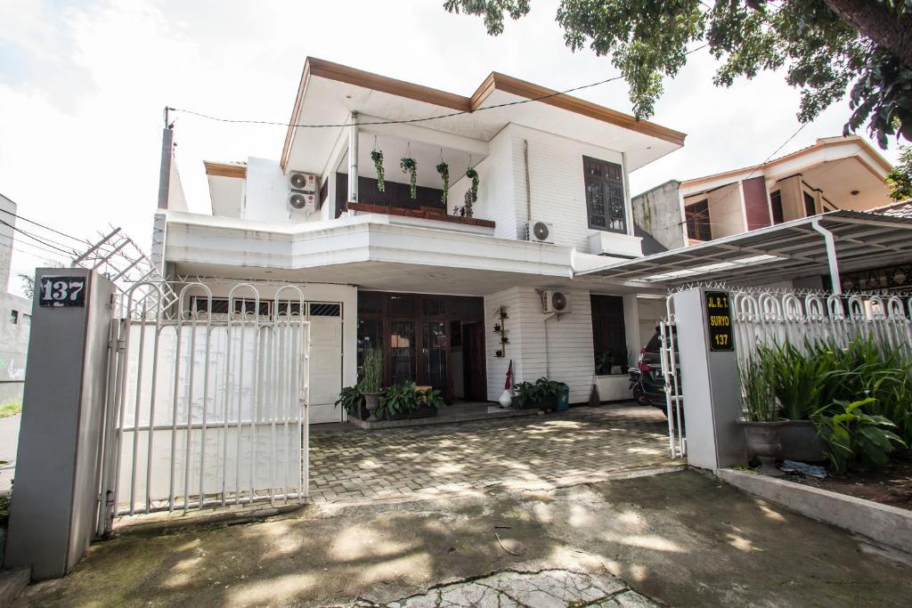 une maison blanche avec une porte en face dans l'établissement RedDoorz near Sanan Malang, à Malang