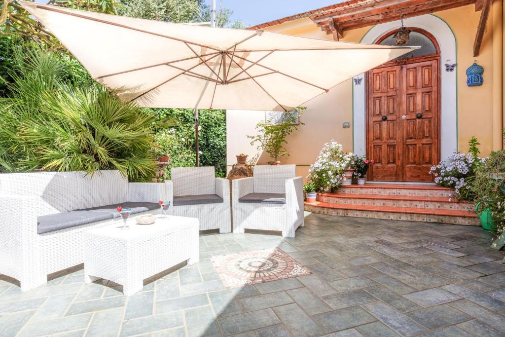 馬薩盧布倫塞的住宿－陽光度假屋，庭院配有遮阳伞、椅子和桌子。