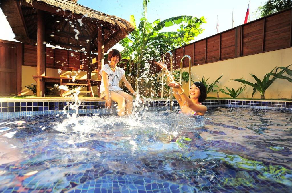 dos niños jugando en una fuente en una piscina en Howard Villa en Kenting