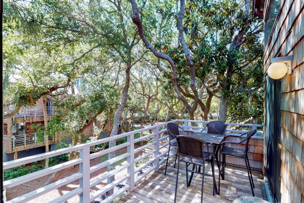 einen Balkon mit einem Tisch und Stühlen auf einem Zaun in der Unterkunft 4406 Windswept in Kiawah Island