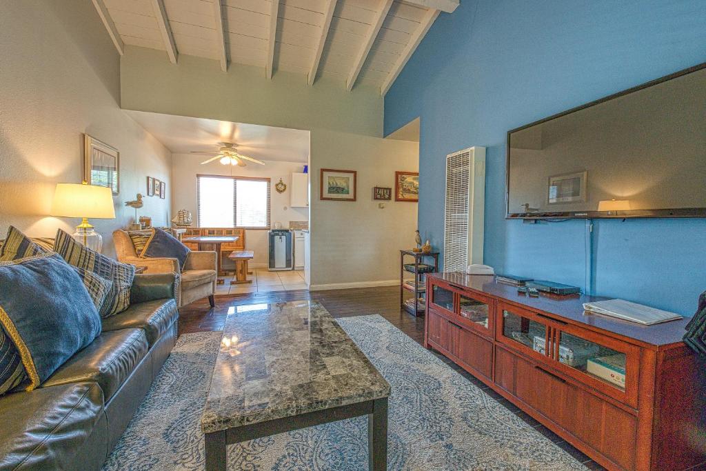 a living room with a couch and a large screen tv at Heart Of The Village in Carlsbad