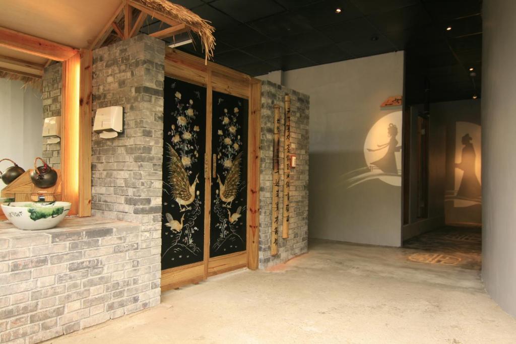 a room with a brick wall with a door at Tingtau Villa in Lugu Lake