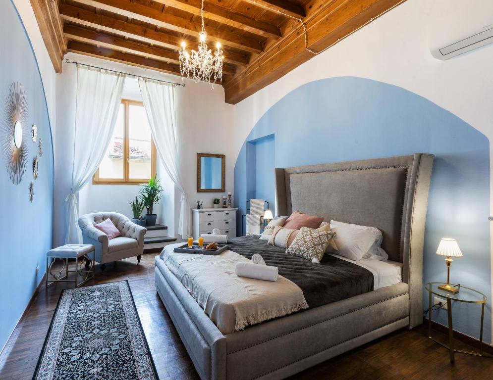 um quarto com uma cama grande e paredes azuis em Historic center Palace - Huge 4 bedrooms Santa Croce apartment apartment - AC in all rooms em Florença