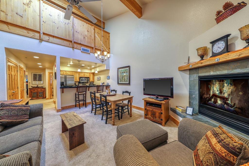 a living room with a fireplace and a dining room at Tavern in Olympic Valley