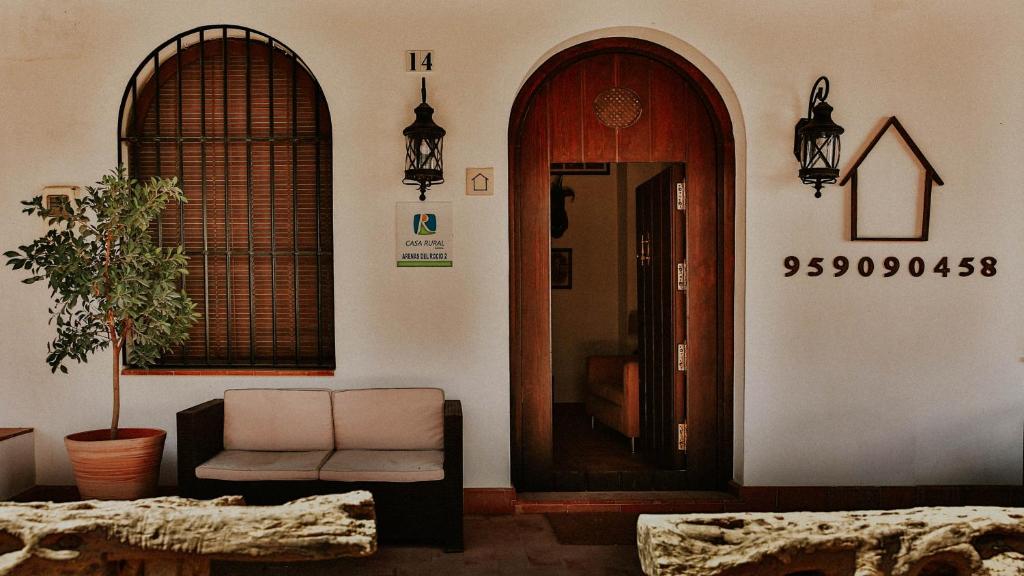 uma sala de estar com um sofá, uma janela e uma porta em Hospedarte Arenas de El Rocio em El Rocio