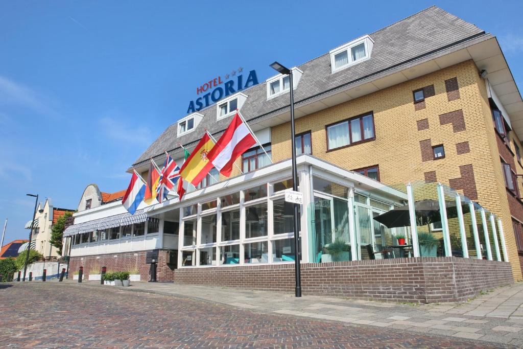 Un bâtiment avec des drapeaux à l'avant dans l'établissement Hotel Astoria, à Noordwijk aan Zee