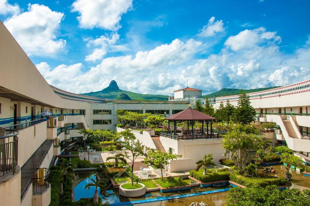 con vistas al patio de un complejo con montañas en el fondo en Howard Beach Resort Kenting, en Kenting