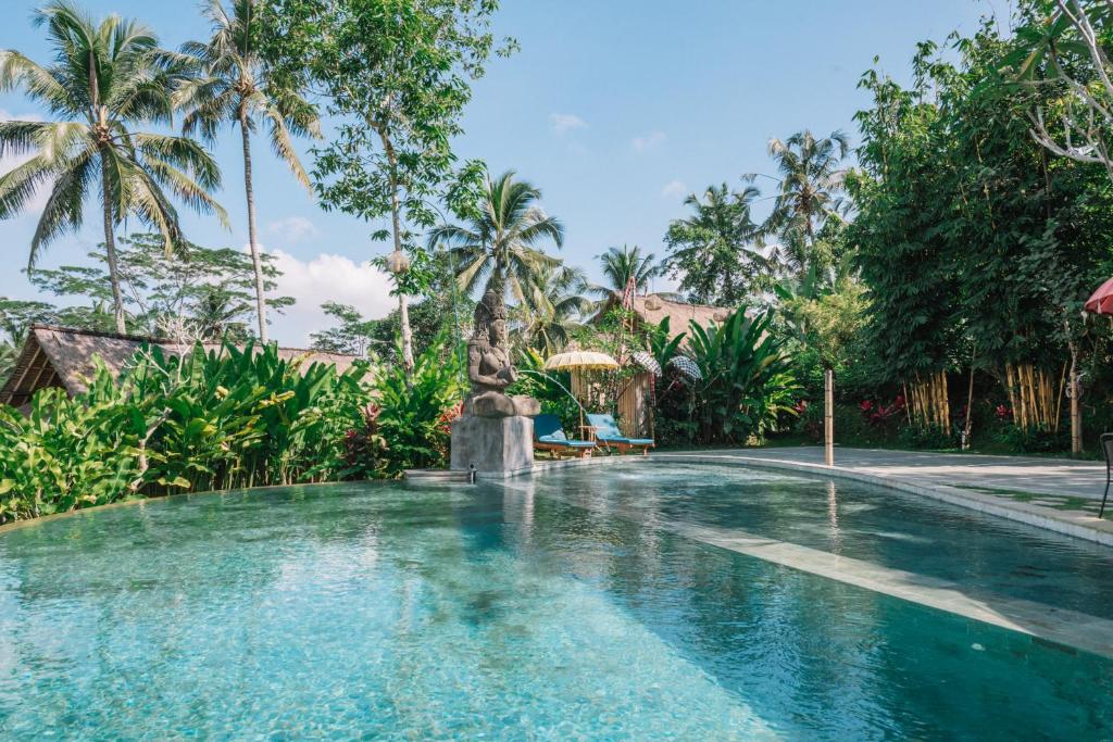 a swimming pool in a resort with a fountain at Bersila La Maison Du Bonheur in Payangan