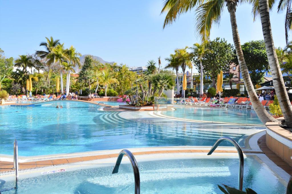 プラヤ・デ・ラス・アメリカスにあるPark Club Europe - All Inclusive Resortのリゾート内のヤシの木がある大型スイミングプール