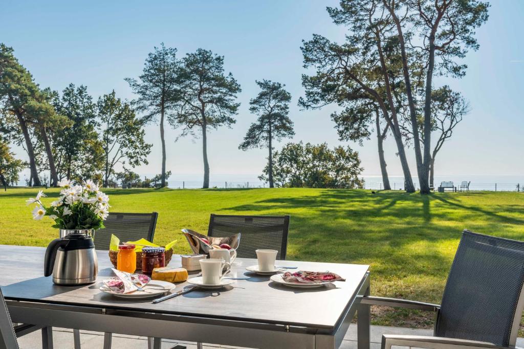 una mesa con comida y vistas a un campo en Terrassenwohnung "Usedom" - Oase am Haff, en Garz